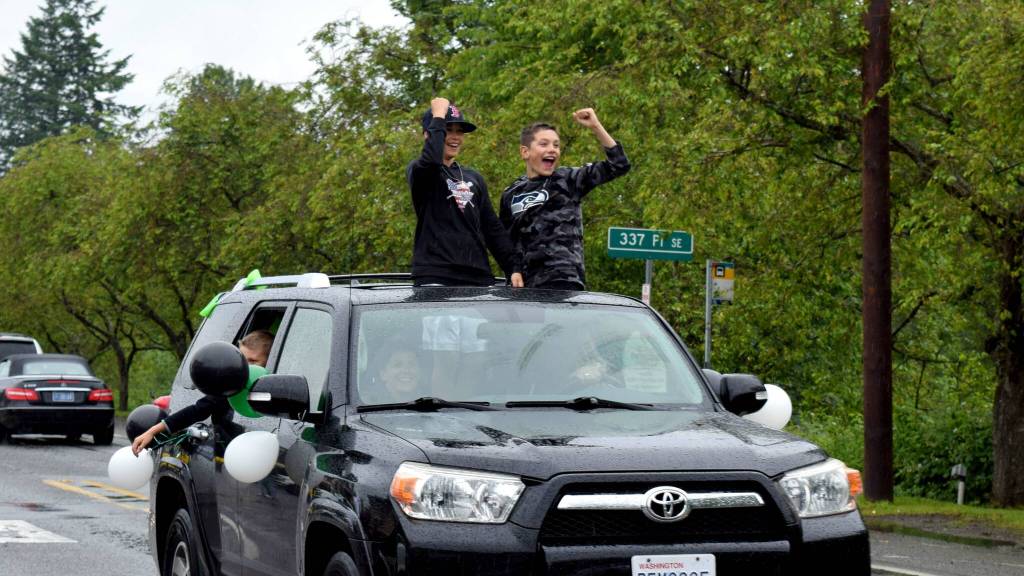 Two boys celebrate during the Fall City Graduate Parade on June 17. Photo Conor Wilson/Valley Record.