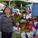 A vendor at The North Bends Farmers market poses with their flowers on June 23.