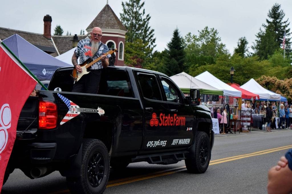 A man plays guitar in the back of a Jeff Warren State Farm Insurance truck during the Snoqualmie Days festival. Photo Conor Wilson/Valley Record.