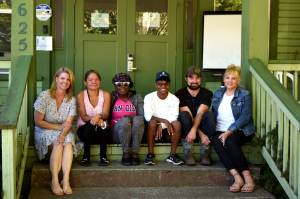 Jennifer Kirk (left), the executive director of Snoqualmie Valley Shelter Services, sits with shelter residents  on the steps of their downtown shelter. The Snoqualmie Valley Shelter Services Reclaiming Stability Luncheon will take place 11 a.m. to 12:30 p.m. Thursday, Sept. 15, at Meadowbrook Farm in North Bend. Photo by Conor Wilson/Valley Record