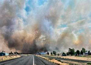 This photo provided by the Washington State Department of Transportation shows smoke from a wildfire burning south of Lind, Wash., on Thursday, Aug. 4, 2022. Sheriffs officials are telling residents in the Eastern Washington town to evacuate because of a growing wildfire south of town that was burning homes. (Courtesy photo)