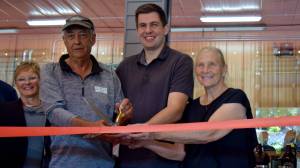 Gary Remlinger (left) and his wife Bonnie (right) join grandson Nathan Sherfey for a ribbon cutting ceremony on Sept. 8. Photo Conor Wilson/Valley Record.