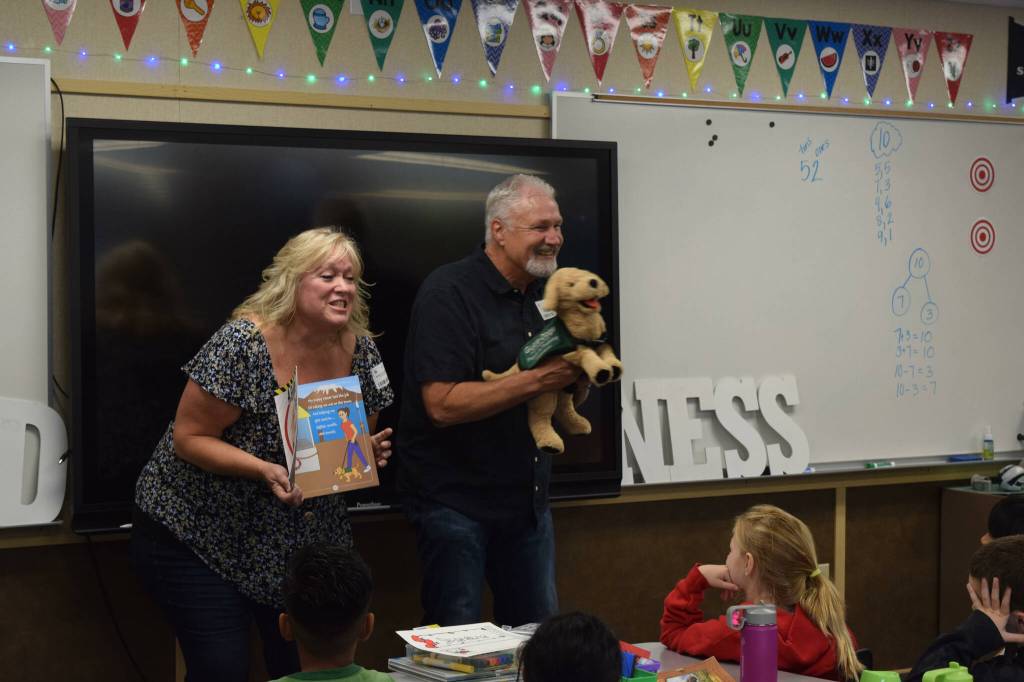 Clark (right) and Karrie Roberts read their book A Guide Dog named Arby to students at North Bend Elementary. Photo by Conor Wilson/Valley Record
