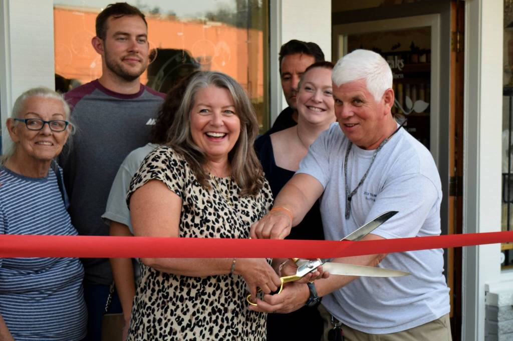 Beverly Davidson, owner of Quill and Ink Tattoo, stands next to family and friends on Oct. 6 as she celebrates the grand opening of her new business in North Bend. Photo Conor Wilson/Valley Record.