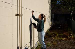Sarah Hughes marks out squares for a new mural in downtown North Bend on Nov. 9. Photos Conor Wilson/Valley Record.