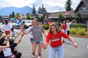 Members of the Mount Si High School basketball team high-five spectators during the Festival at Mount Si Parade in August. The festival was one of several this year to return in-person for the first time since the pandemic. File photo