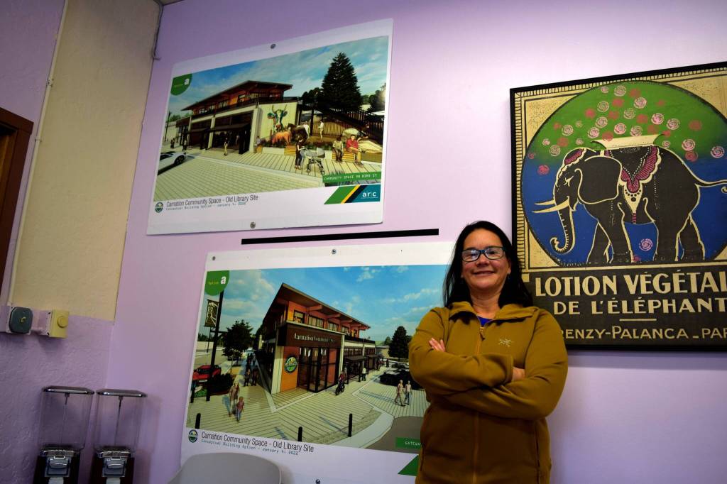 Ana Cortez, Carnations city manager, poses in front of designs for the new city hall building being built at the old library site. Photo by Conor Wilson/Valley Record