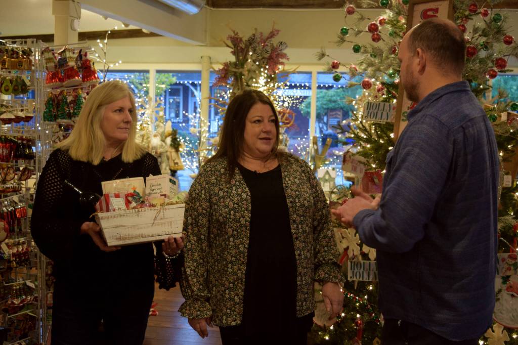Carousel owner Joelle Gibson (middle) and store manager Cathy Gregory talk with Brian Davis.