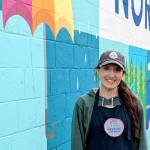 Photo by Conor Wilson/Valley Record.
Hayley Raff, owner of Pressed on Main, poses in front of a mural on the side of her business at 208 Main Ave. S., North Bend.