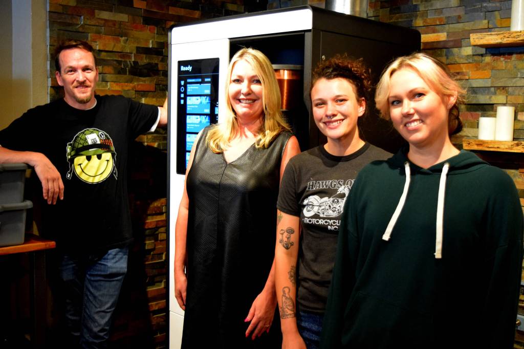 Tanya Guinn, middle left, poses with staff members in front of Trail Youths new coffee roaster. Photo by Conor Wilson/Valley Record.