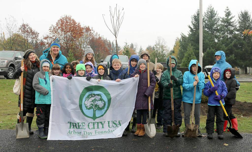 File Photo
Volunteers pose with the Tree City USA banner before getting to work on planting trees in North Bend.