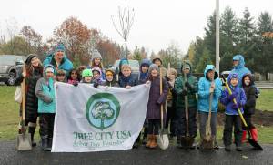 File Photo
Volunteers pose with the Tree City USA banner before getting to work on planting trees in North Bend.
