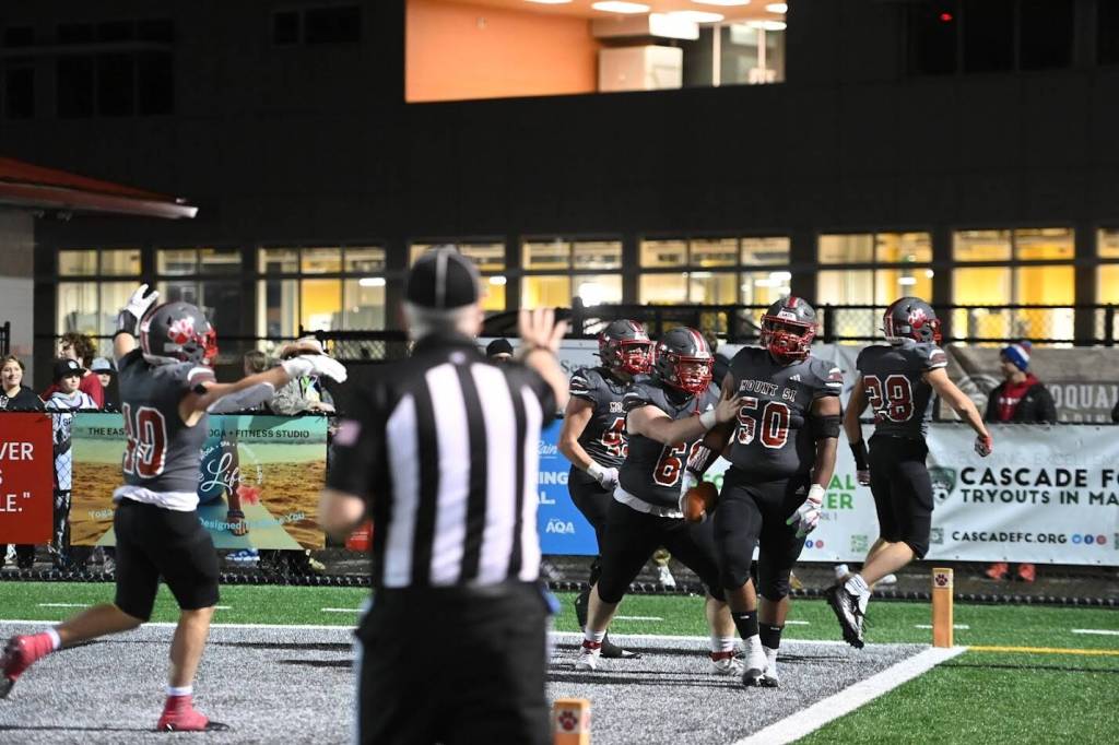 Photo courtesy of Calder Productions. Wildcats celebrate with teammate Jayden Wells after he scores on a pick-six in a 39-14 win over Glacier Peak High School on Nov. 3.