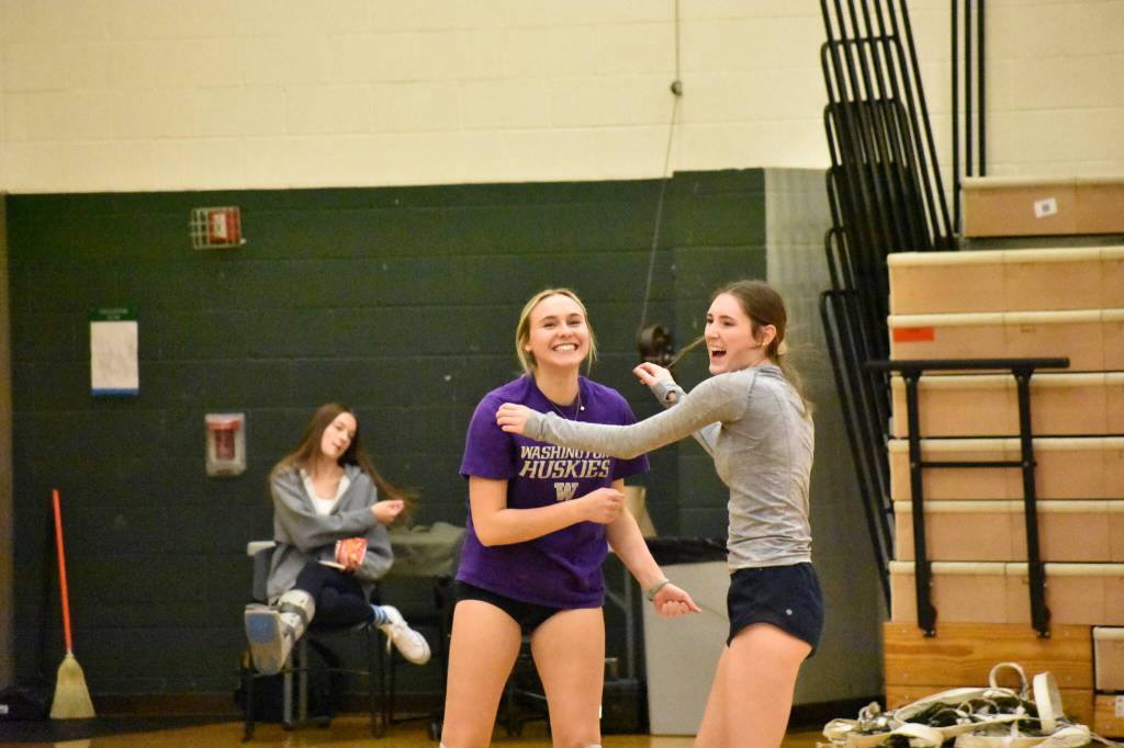 Rylee Booth (purple shirt) and Rachel Maginnis have a laugh in warm-ups. (Photos by Ben Ray / Sound Publishing)