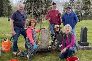 Volunteers clean a headstone at the Fall City Cemetery. From left: (standing) Gene Stevens, Rick Divers, Richard Heilser; (kneeling) Anne Neilson, Donna Driver-Kummen, Cindy Parks. (Photo courtesy of Cindy Parks.)