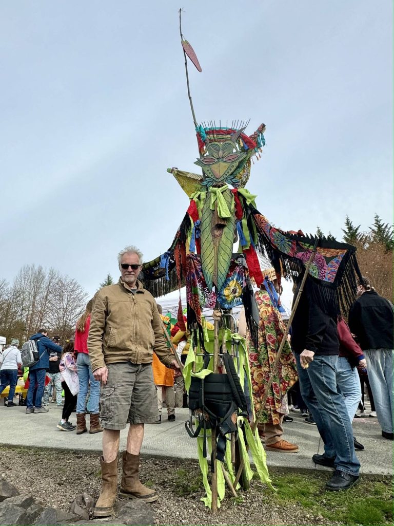 Artist Dan Cautrell poses with his wood-carved praying mantis at Depot Park on Saturday, March 30. Cautrell creates a new piece of art for each March of the Vegetables. Photos by Grace Gorenflo/For the Valley Record