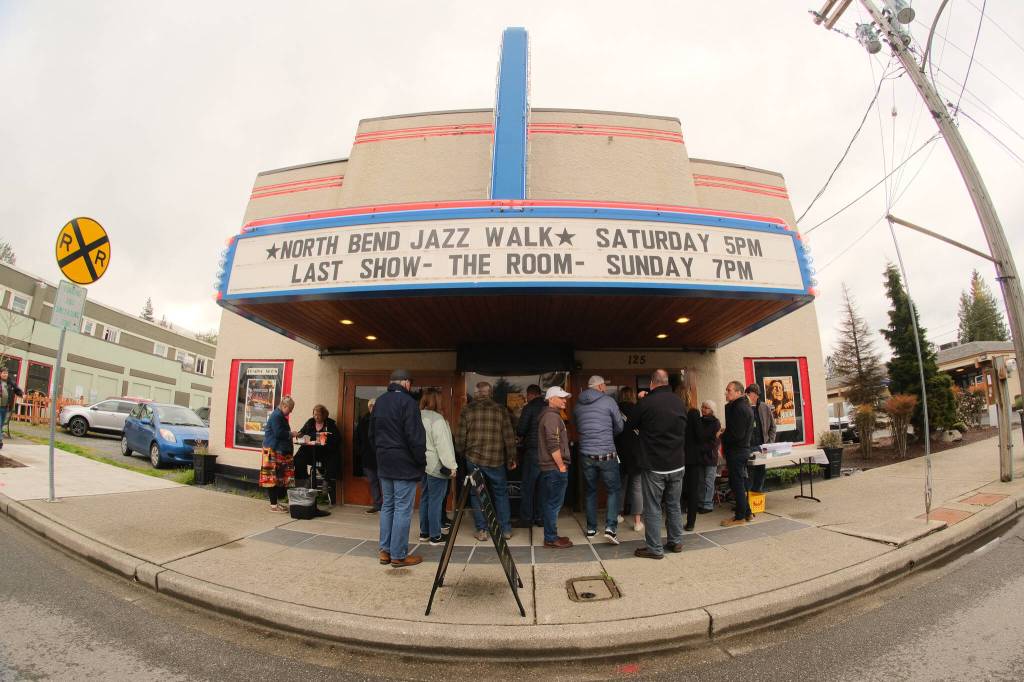The thirteenth annual North Bend Jazz Walk was held April 27. Nineteen venues throughout downtown North Bend hosted 28 jazz bands with at least 100 total musicians from 5 p.m. to midnight. Learn more at northbendjazzwalk.com. Pictured: Excited guests hide from the rain under the cover of the North Bend Theatre. Photos by Ben Magnus/For the Valley Record