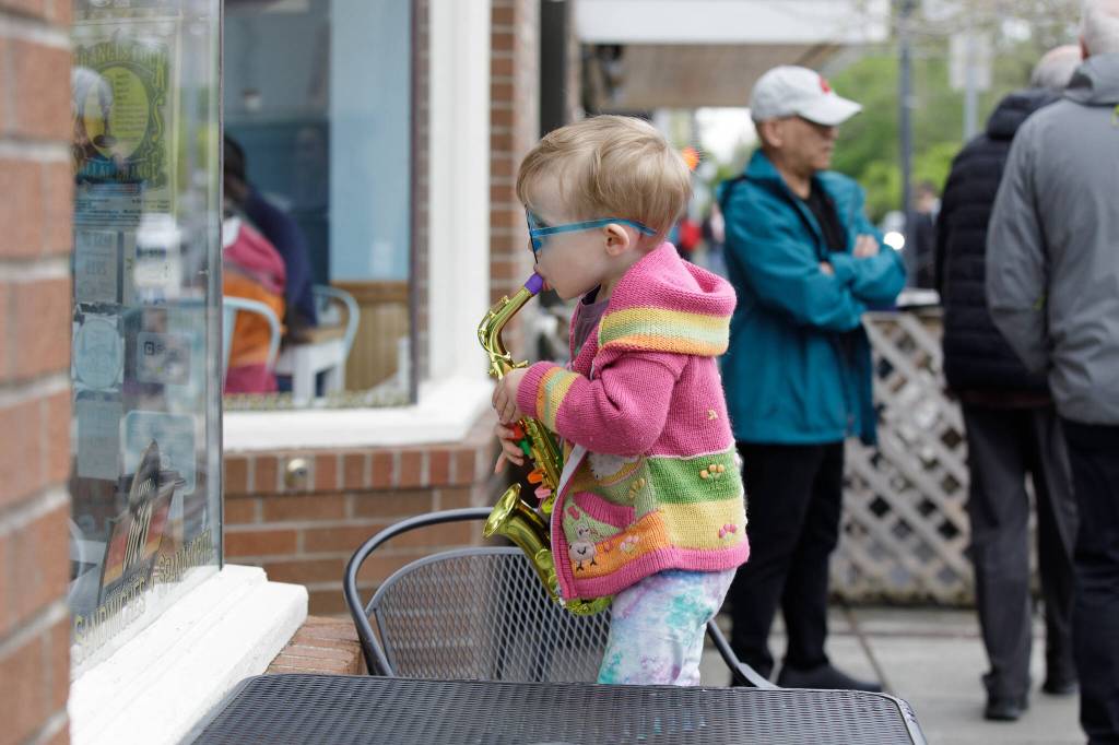 Little kid standing at the window of North Bend Bakery, trying to imitate the Jake Bergevin Trio inside.