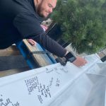 Tribal member and Fireweed Cannabis Manager Robbie de los Angeles signing the beam. (Photo by Bill Shaw/Valley Record)