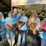 Members of the Duvall Farmers Market team pose with fresh flowers from market vendor Flower Day Farm. From left: board member Pat Martinell, board member Diane Litts, volunteer Jim McGraw, volunteer Liz Geary Scott, market manager Anaya Stout and board member Pati McGraw. Courtesy of Alex Yearout