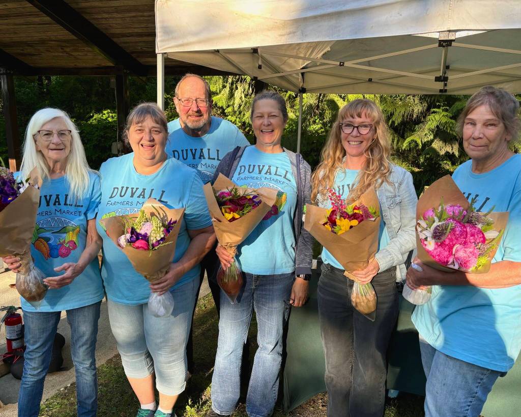 Members of the Duvall Farmers Market team pose with fresh flowers from market vendor Flower Day Farm. From left: board member Pat Martinell, board member Diane Litts, volunteer Jim McGraw, volunteer Liz Geary Scott, market manager Anaya Stout and board member Pati McGraw. Courtesy of Alex Yearout