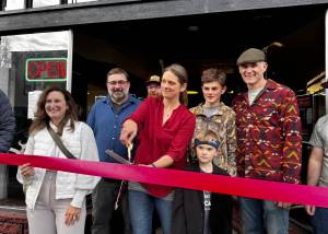 Christeena Marzolf prepares to cut a celebratory ribbon with family and friends at Falling River Meats Oct. 17, 2024. From left: Valerie Pacheco, Snoqualmie Valley Chamber of Commerce board secretary; Justin Fitch, Falling River Meats chef; Christeena Marzolf, Falling River Meats co-owner; Marcus Marzolf; Rowan Marzolf; Darron Marzolf, Falling River Meats co-owner. (Photo by Grace Gorenflo/Valley Record)