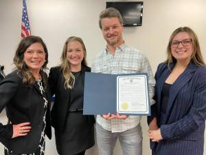 Jordan Perry, holding Carnations Jordan Perry Month proclamation, stands for a photo with members of Carnation staff. Courtesy of the city of Carnation