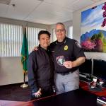 Snoqualmie Police Chief Brian Lynch (right) stands for a photo with evidence technician L.T. Liebetrau and the department's new breast cancer awareness patches. (Grace Gorenflo/Valley Record)