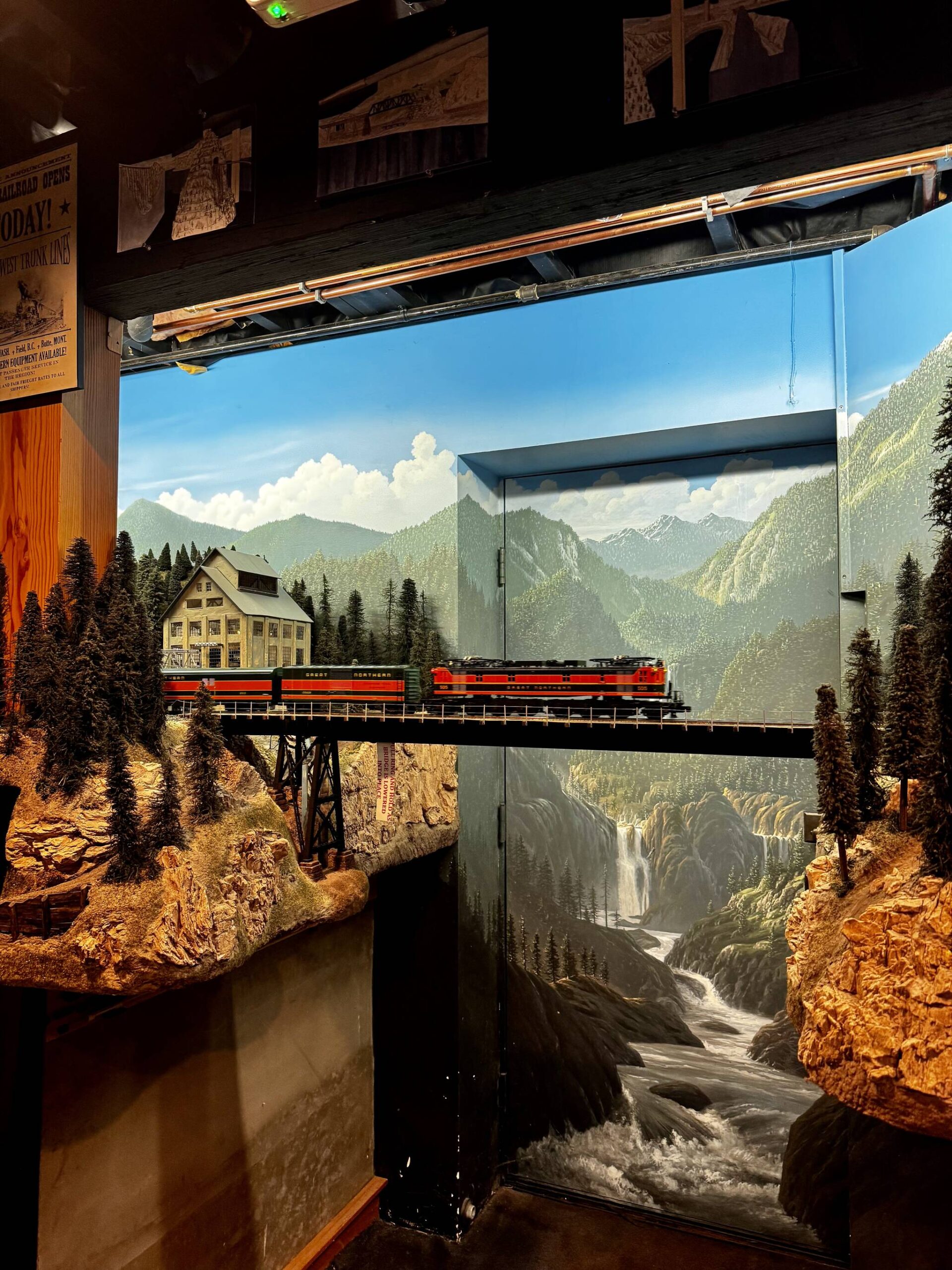A model train crosses a bridge in front of the exterior door to Peter Hamblings basement. The basement was built for this project. (Grace Gorenflo/Valley Record)