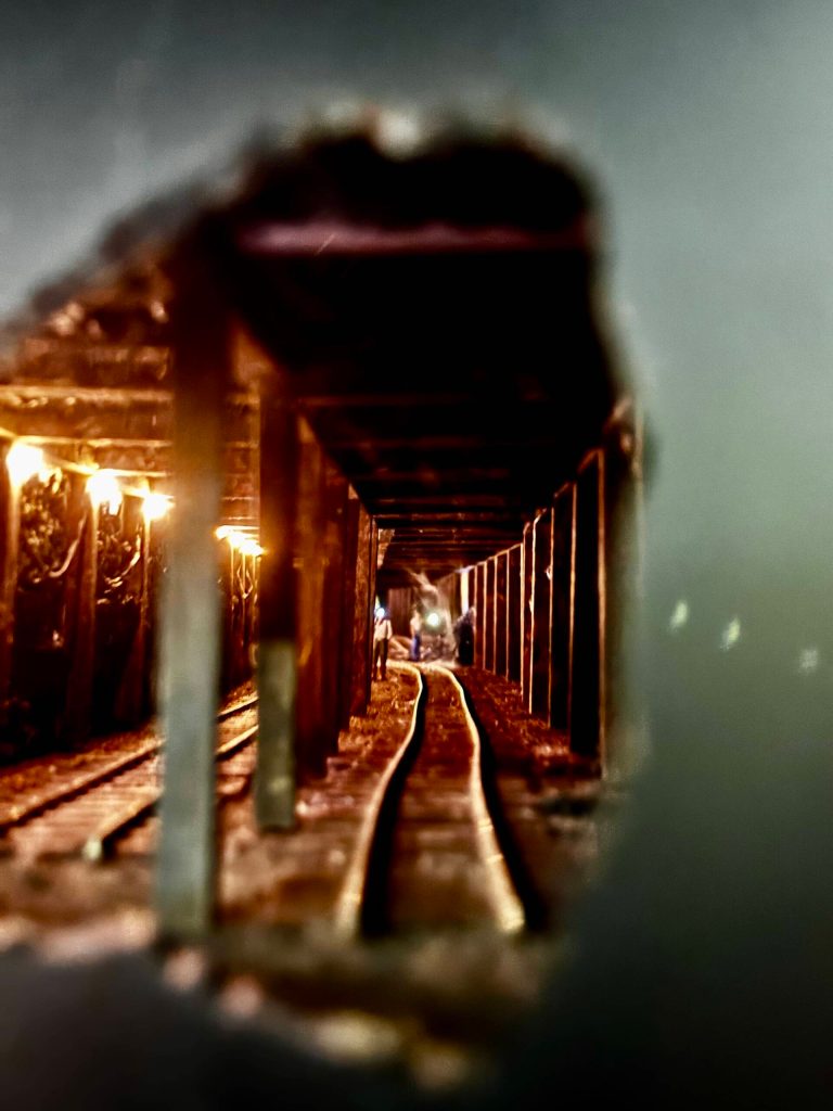 Miniature figures are seen working on a railroad in a tunnel. The scene is set up in a hole in the wall. (Grace Gorenflo/Valley Record)