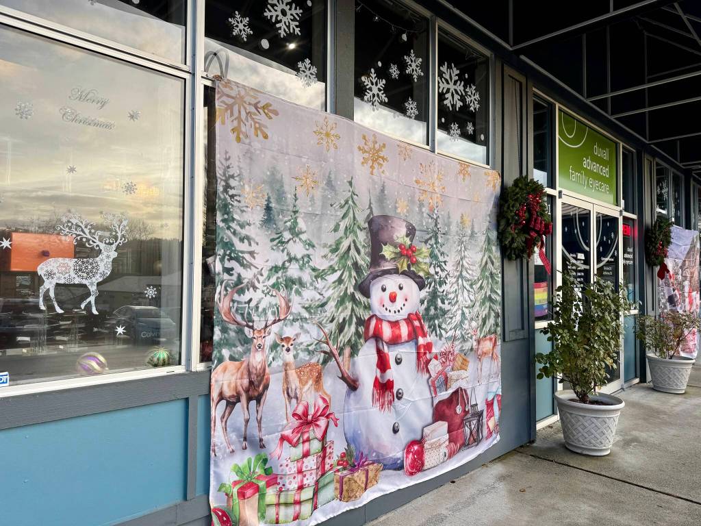 Duvall Advanced Family Eye Cares windowscape includes Christmas-themed tapestries and other decor. (Grace Gorenflo/Valley Record)