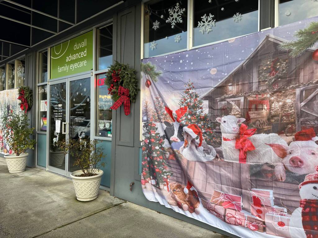 Duvall Advanced Family Eye Cares windowscape includes Christmas-themed tapestries and other decor. (Grace Gorenflo/Valley Record)