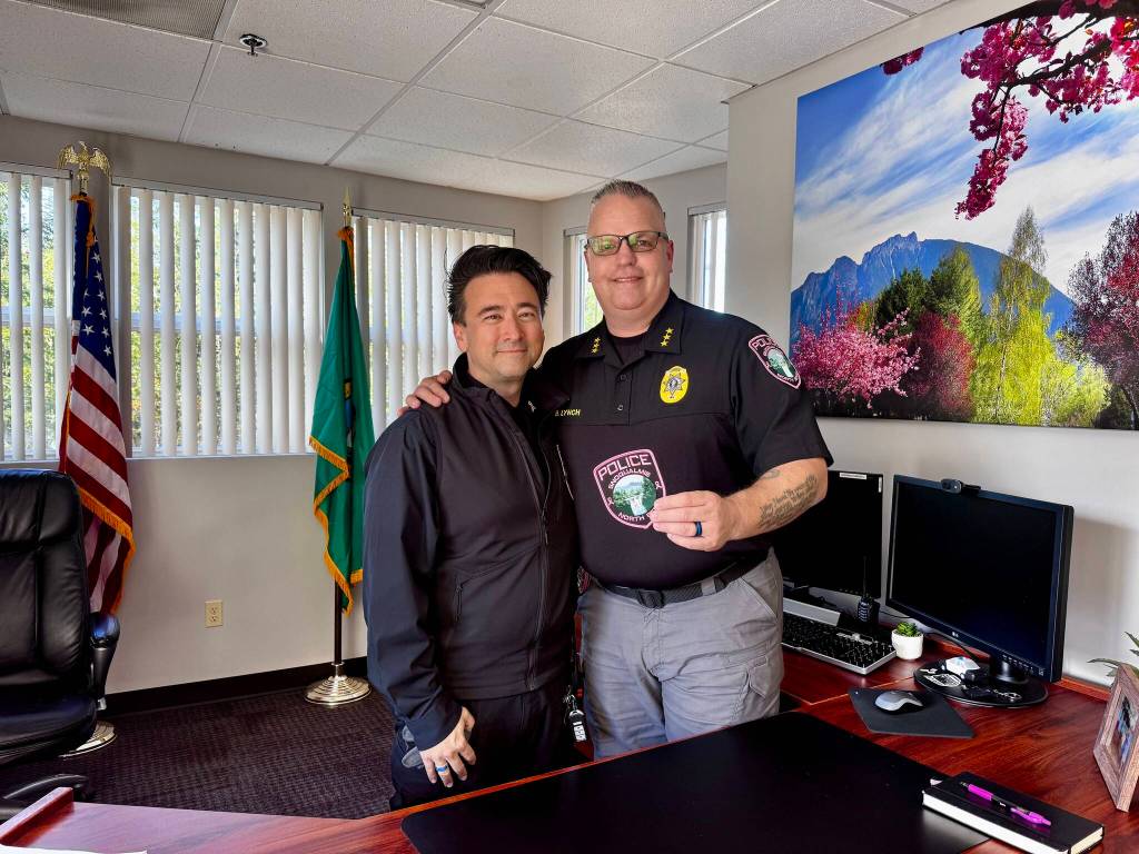 Snoqualmie Police Chief Brian Lynch (right) stands for a photo with evidence technician L.T. Liebetrau and the departments new breast cancer awareness patches. Grace Gorenflo/Valley Record