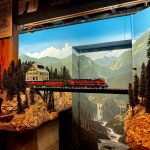 A model train crosses a bridge in front of the exterior door to Peter Hamblings basement. The basement was built for this project. (Grace Gorenflo/Valley Record)