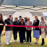Snoqualmie Valley Healing Center Chaplain Patti Yetneberk, surrounded by board members and local officials, cuts the ribbon at the centers ribbon-cutting ceremony, March 12, 2025. Grace Gorenflo/Valley Record