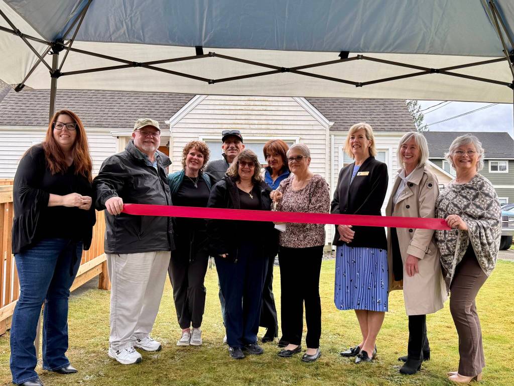 Snoqualmie Valley Healing Center Chaplain Patti Yetneberk, surrounded by board members and local officials, cuts the ribbon at the centers ribbon-cutting ceremony, March 12, 2025. (Grace Gorenflo/Valley Record)