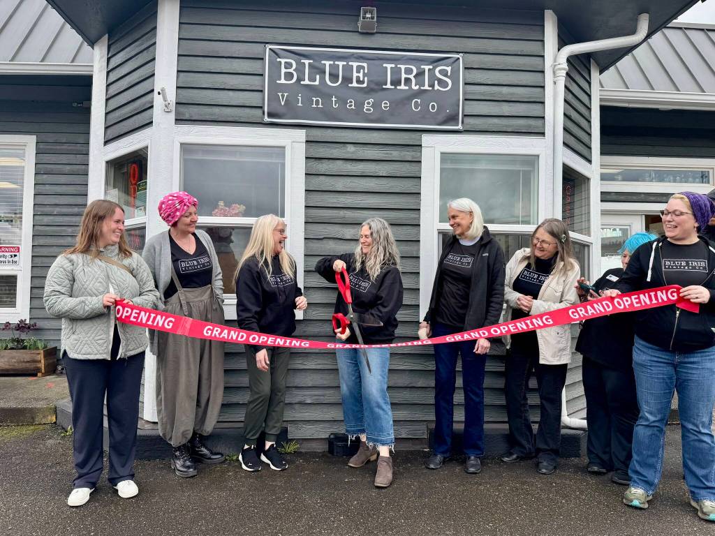 Blue Iris Vintage Co. owner Jessica Miller prepares to cut the ribbon, surrounded by friends and shop vendors, at her shops ceremony March 22, 2025. (Grace Gorenflo/Valley Record)