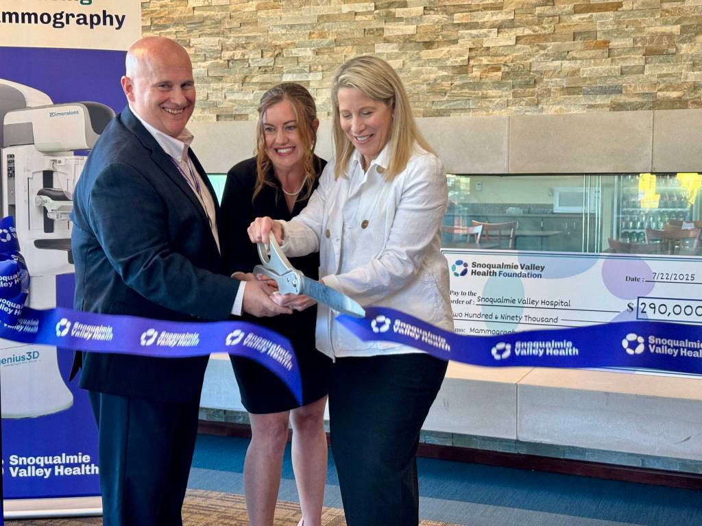 Snoqualmie Valley Health imaging manager Steve Bradshaw, CEO Renée Jensen and radiologist Kara Carlson cut the ribbon at the opening of the hospitals mammography suite, July 22, 2025. (Grace Gorenflo/Valley Record)