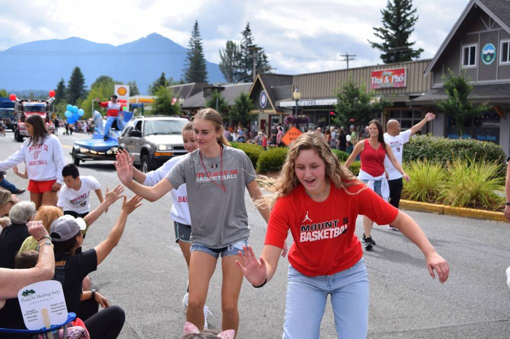 Members of Mount Si High Schools basketball team high-five parade spectators during the Festival at Mt Si. File photo