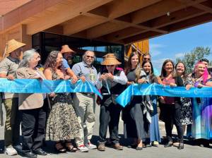 Robert de los Angeles, chairperson of the Snoqualmie Tribal Council, cuts the ribbon at the opening of the Snoqualmie Casinos hotel, surrounded by tribal members, Aug. 8, 2025. (Grace Gorenflo/Valley Record)