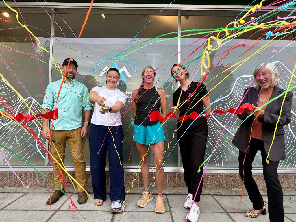 Theresa Haley cuts the ribbon at a ceremony for her physical therapy clinic, Alpine Mechanics, in North Bend, July 31, 2025. She is joined by her husband, her staff and North Bend Mayor Mary Miller (right). Grace Gorenflo/Valley Record