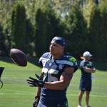 Seattle Seahawks Running Back Zach Charbonnet tosses a ball to a Seahawks coach. Ben Ray / Sound Publishing