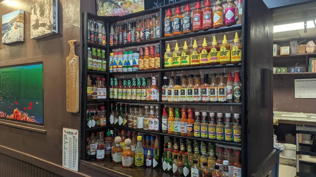 Carnation Cafes hot sauce wall, which includes well over 50 varieties of hot sauce for customers to enjoy. Photo courtesy of Carnation Cafe