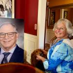 Sarah Perry and her dog, Sadie, sit with the photo of Bill Ramos used for his celebration of life in their Issaquah home, July 30, 2025. Perry said she keeps the photo in her home office so Ramos is always with her. Photo by Grace Gorenflo/Valley Record