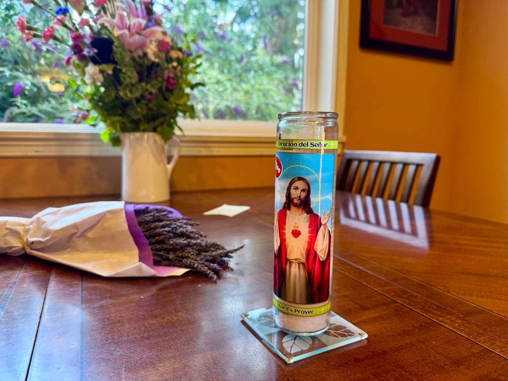 A Lords Prayer candle sits in the dining room of Sarah Perry and Bill Ramoss Issaquah home, July 30, 2025. Perry said it is tradition that the candle stay lit through the end of the year to honor Ramos. Photo by Grace Gorenflo/Valley Record