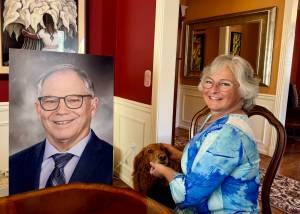 Sarah Perry and her dog, Sadie, sit with the photo of Bill Ramos used for his celebration of life in their Issaquah home, July 30, 2025. Perry said she keeps the photo in her home office so Ramos is always with her. (Grace Gorenflo/Valley Record)