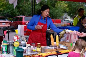A vendor serves corn to a customer at the North Bend Farmers Market, Sept. 11, 2025. (Grace Gorenflo/Valley Record)