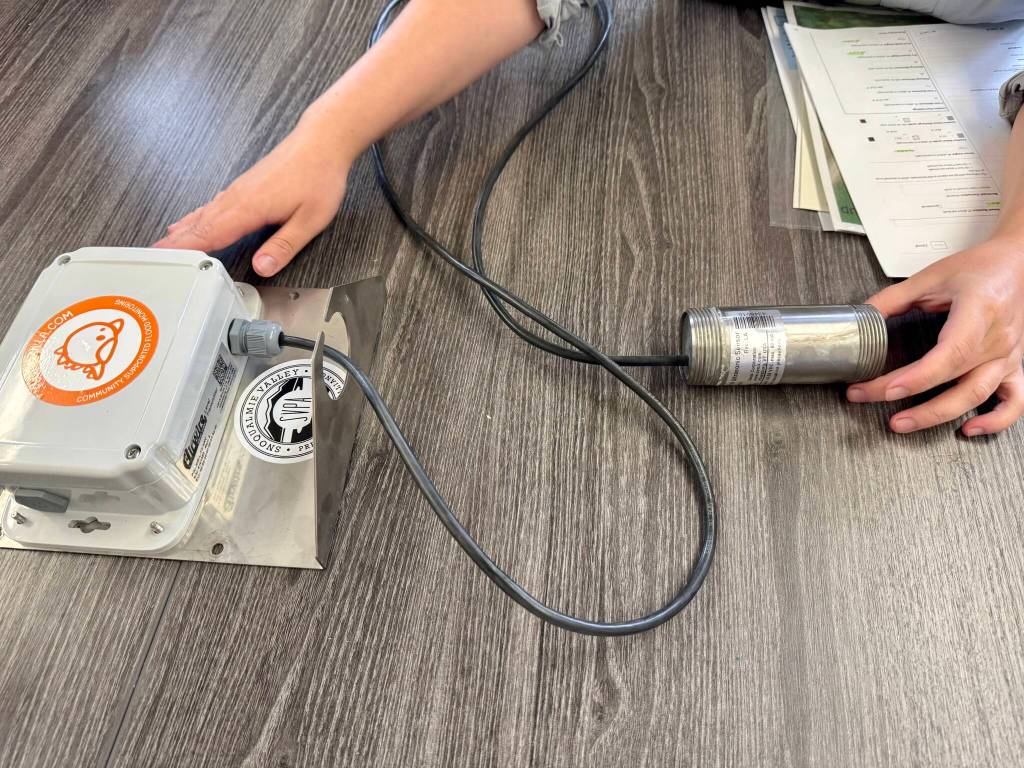 Floodzilla field scientist Regina Fletcher shows a Floodzilla gauge and transmitter not in use, Aug. 6, 2025. (Grace Gorenflo/Valley Record)