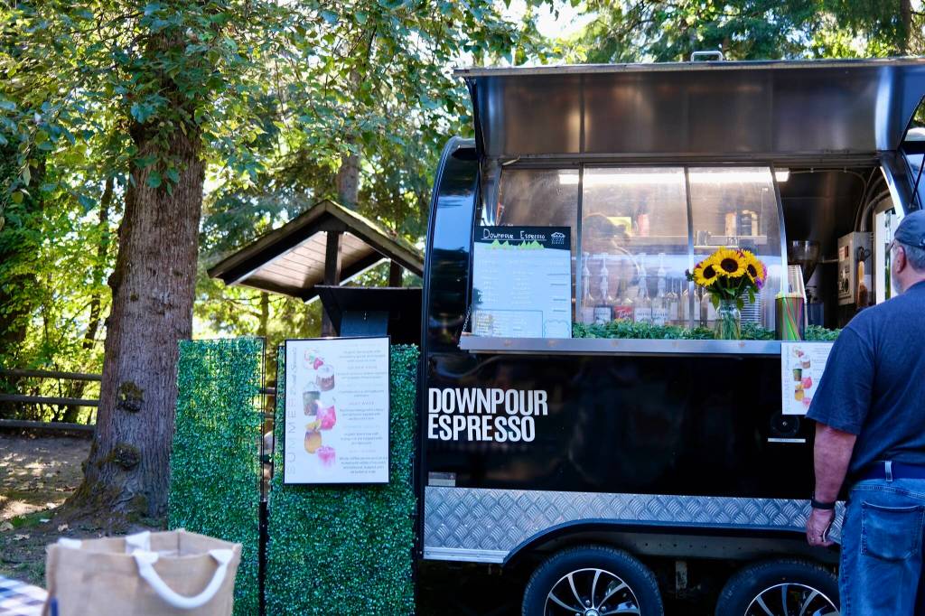 A customer orders from the Downpour Espresso coffee cart at the Duvall Farmers Market, Aug. 21, 2025. (Grace Gorenflo/Valley Record)