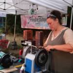 Vendor Erin Cox sharpens knives for customers at the Duvall Farmers Market, Sept. 4, 2025. (Grace Gorenflo/Valley Record)